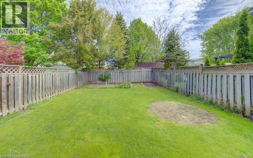 Spacious backyard featuring a lush green lawn, full perimeter privacy fencing, and mature surrounding trees - 603 Pinerow Crescent Unit# B, Waterloo, ON 