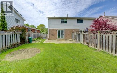 Expansive green lawn with a patio area, privacy fencing, and mature perimeter trees - 603 Pinerow Crescent Unit# B, Waterloo, ON 