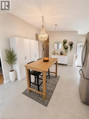 Expansive kitchen area featuring large format tile flooring, a chandelier light fixture, and a built-in white cabinetry wall - 241 Thorner Drive, Hamilton, ON - Indoor Photo Showing Other Room