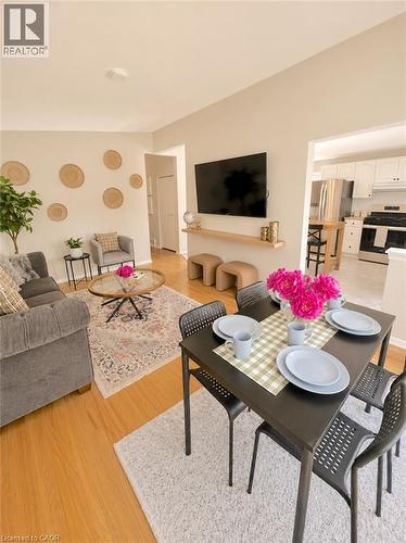 Open-concept living and dining area featuring wood-finish flooring, neutral wall tones, and a recessed ceiling light - 241 Thorner Drive, Hamilton, ON - Indoor Photo Showing Living Room