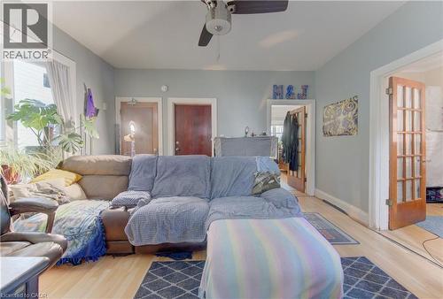 Living area featuring light wood-finish flooring, light blue wall paint, a ceiling fan, and white trim - 48 Breithaupt Street, Kitchener, ON - Indoor Photo Showing Living Room