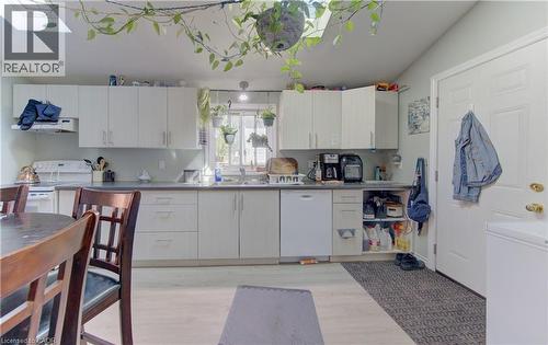 Kitchen featuring extensive white cabinetry, a skylight, and light wood-finish flooring - 48 Breithaupt Street, Kitchener, ON - Indoor Photo Showing Kitchen