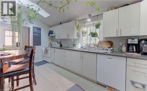 Functional kitchen featuring light-toned cabinetry, a skylight, a double-basin sink, and a built-in dishwasher - 48 Breithaupt Street, Kitchener, ON - Indoor