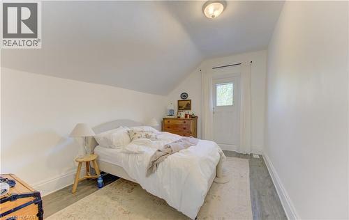 Upper bedroom with angled ceiling, white walls, and access to outdoor porch sitting area - 48 Breithaupt Street, Kitchener, ON - Indoor Photo Showing Bedroom