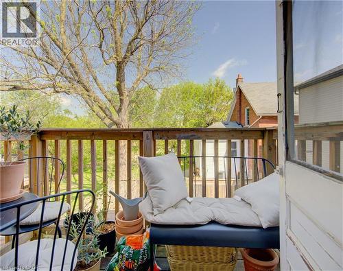 Upper unit outdoor porch sitting area featuring a wood railing and wood-finish flooring - 48 Breithaupt Street, Kitchener, ON - 