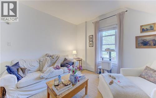 Bright interior space featuring a window with natural light, light-colored walls, and a wall-mounted sconce - 48 Breithaupt Street, Kitchener, ON - Indoor