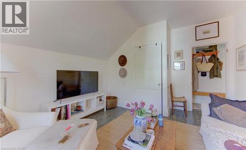 Interior space featuring a vaulted ceiling, wood-finish flooring, white walls, and a built-in entryway bench with shelving and hooks - 48 Breithaupt Street, Kitchener, ON - Indoor Photo Showing Living Room
