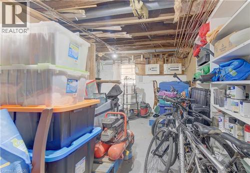 Unfinished basement space featuring exposed ceiling joists and support beams, dedicated storage shelving, and a small basement window - 48 Breithaupt Street, Kitchener, ON - Indoor Photo Showing Basement
