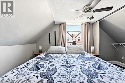 Attic space featuring a window, built-in shelving, vaulted ceilings, and a ceiling fan - 23 Britannia Avenue, Hamilton, ON - Indoor Photo Showing Bedroom