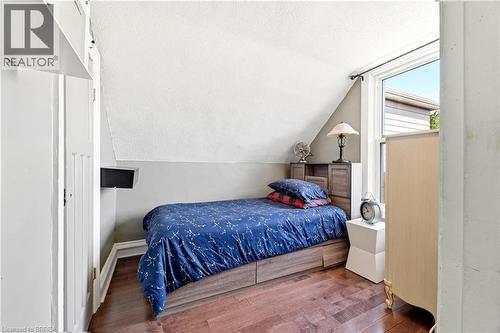 Attic room featuring rich wood-finish flooring, a single window, and a built-in wall shelf - 23 Britannia Avenue, Hamilton, ON - Indoor Photo Showing Bedroom