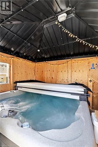 Indoor hot tub featuring a partial cover and bubbling water - 23 Britannia Avenue, Hamilton, ON - Indoor