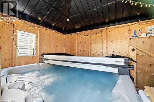 Enclosed hot tub area featuring wood paneling, a black metal roof structure, and a functional window - 23 Britannia Avenue, Hamilton, ON - Indoor