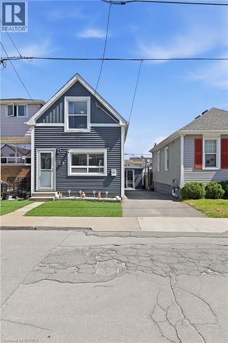 Gabled residence featuring deep blue horizontal siding and white trim - 23 Britannia Avenue, Hamilton, ON - Outdoor