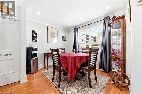 Bright dining area featuring hardwood flooring, crown molding, recessed lighting, and a window with plantation shutters - 23 Britannia Avenue, Hamilton, ON - Indoor Photo Showing Dining Room