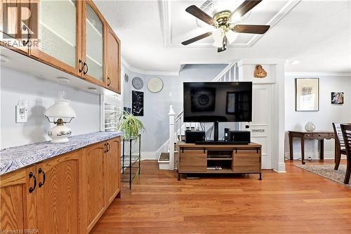 Warm wood-finish flooring extending throughout, featuring a coffered ceiling with a ceiling fan - 23 Britannia Avenue, Hamilton, ON - Indoor