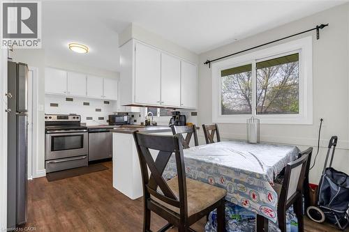 Kitchen featuring wood-finish flooring, white cabinetry, and stainless steel appliances - 46 Beaconsfield Drive, Hamilton, ON - Indoor Photo Showing Dining Room