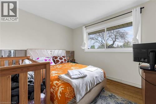 Bedroom featuring a large window, light-toned walls, and wood-finish flooring - 46 Beaconsfield Drive, Hamilton, ON - Indoor Photo Showing Bedroom