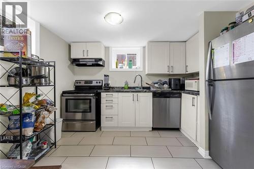 Kitchen featuring white cabinetry, dark countertops, a stainless steel range, a stainless steel dishwasher, and tile flooring - 46 Beaconsfield Drive, Hamilton, ON - Indoor Photo Showing Kitchen