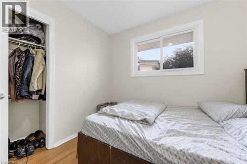 Room featuring light-toned walls, wood-finish flooring, a white-framed window, and a built-in closet with a hanging rod and shelving - 46 Beaconsfield Drive, Hamilton, ON - Indoor Photo Showing Bedroom