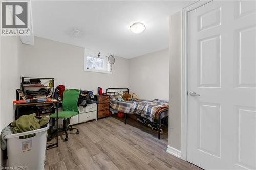 Room featuring wood-finish flooring, light neutral wall paint, and a white six-panel interior door with brushed nickel hardware - 46 Beaconsfield Drive, Hamilton, ON - Indoor Photo Showing Bedroom