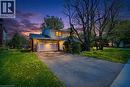 Two-story residence featuring a two-car garage with transom windows, stone veneer accents, and a shingled roof - 46 Birchcliff Avenue, Kitchener, ON  - Outdoor 