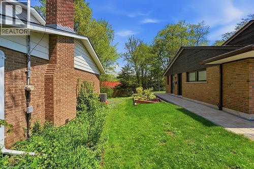 Brick exterior with a prominent chimney, a well-maintained lawn, and a stone walkway - 46 Birchcliff Avenue, Kitchener, ON - Outdoor With Exterior
