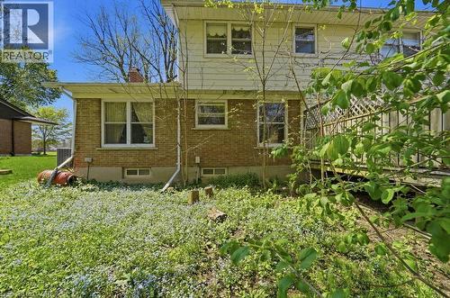 Brick and siding exterior featuring multiple windows, white trim, and an elevated wooden deck with lattice accents - 46 Birchcliff Avenue, Kitchener, ON - Outdoor