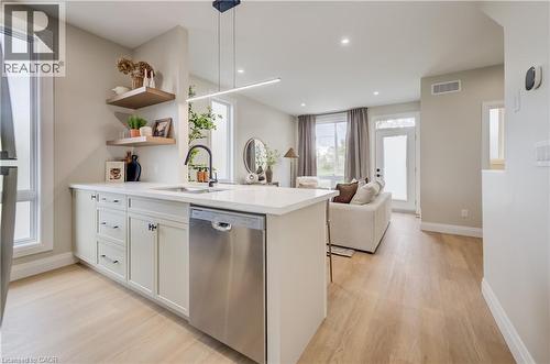Modern kitchen featuring a white countertop island with an undermount sink and a stainless steel dishwasher - 210 Heritage Drive Unit# Main, Kitchener, ON - Indoor Photo Showing Kitchen