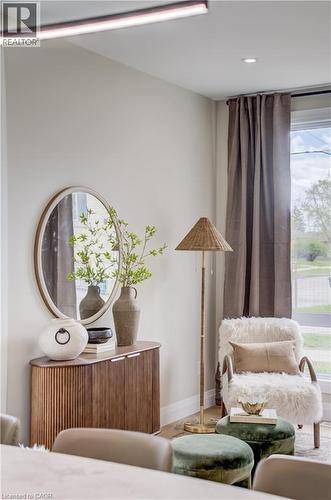 Dedicated wall space featuring a wood-finish console cabinet with reeded details and a round wall mirror - 210 Heritage Drive Unit# Main, Kitchener, ON - Indoor Photo Showing Other Room