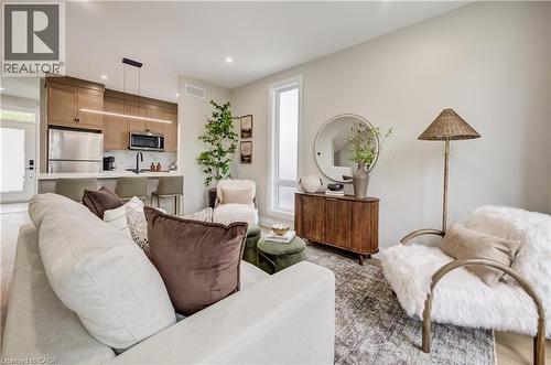 Open-concept living space with a contemporary kitchen featuring stainless steel appliances, light wood-finish cabinetry, and a central island with seating - 210 Heritage Drive Unit# Main, Kitchener, ON - Indoor Photo Showing Living Room