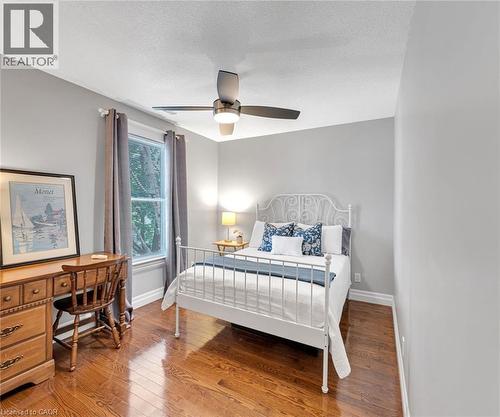 Room featuring wood-finish flooring, a window with trim, a ceiling fan with integrated lighting, and light-toned wall finishes - 546 Hurd Avenue, Burlington, ON - Indoor Photo Showing Bedroom