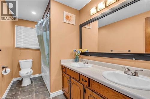 Full bath with double vanity, shower / tub combo with curtain, and dark tile patterned flooring - 146 Bechtel Drive, Kitchener, ON - Indoor Photo Showing Bathroom