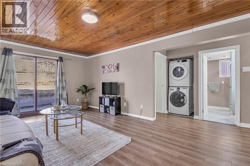 Living area featuring wooden ceiling, stacked washer / dryer, and wood finished floors - 146 Bechtel Drive, Kitchener, ON - Indoor