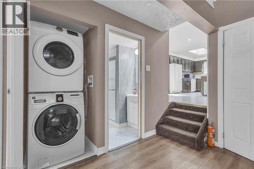 Laundry area featuring stacked washer and clothes dryer, light wood-style flooring, and recessed lighting - 146 Bechtel Drive, Kitchener, ON - Indoor Photo Showing Laundry Room