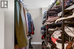 Organized closet space featuring wood-finish flooring and light-toned walls - 