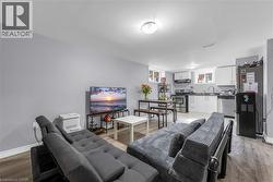 Open-concept living space featuring wood-finish flooring and light gray painted walls - 