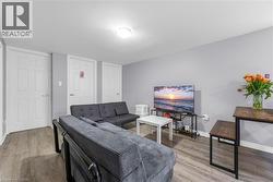 Living area with light wood-finish flooring, light gray wall paint, and white trim - 