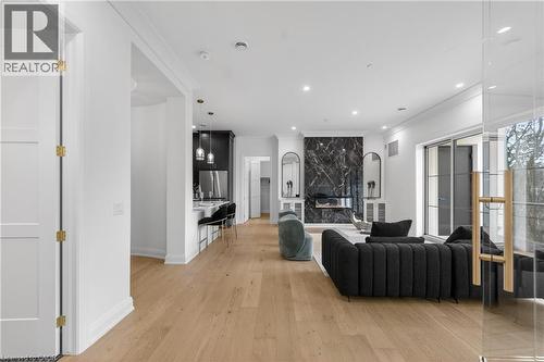 Spacious living area featuring light wood-finish flooring, recessed lighting, and crown molding - 2 Arbourvale Common Unit# 209, St. Catharines, ON - Indoor