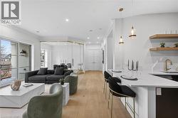 Open-concept living area featuring light wood-finish flooring and recessed lighting throughout - 