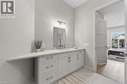 Spacious vanity with light gray cabinetry, a white countertop, and a rectangular undermount sink - 