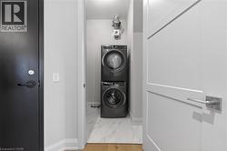 Dedicated laundry area featuring stacked front-load washer and dryer units - 