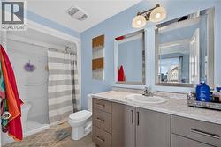 Bathroom featuring a shower-tub combination, a vanity with an integrated sink, a light-toned countertop, and dual framed mirrors - 