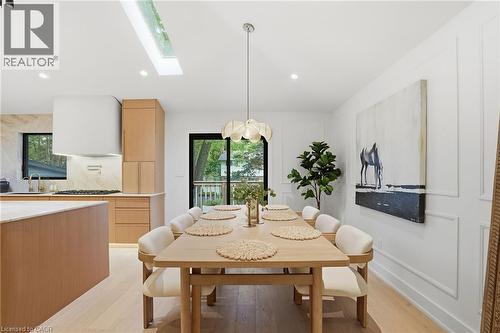Open-concept dining area featuring light wood-finish flooring, a contemporary pendant light fixture, and a skylight - 345 Rankin Drive, Burlington, ON - Indoor Photo Showing Dining Room