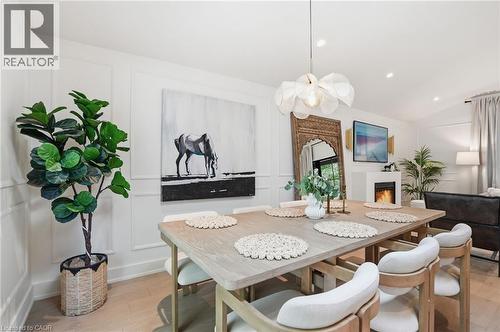 Dining area featuring wood-finish flooring, wainscoting, and a contemporary pendant light fixture - 345 Rankin Drive, Burlington, ON - Indoor Photo Showing Dining Room