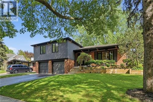 Split-level residence featuring a two-car garage, dark gray siding, and brick accents - 345 Rankin Drive, Burlington, ON - Outdoor