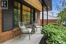 Brick facade featuring a covered porch with a wood-finish ceiling, recessed lighting, and dark columns - 345 Rankin Drive, Burlington, ON  - Outdoor With Exterior 