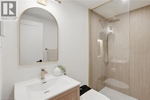 Bathroom featuring a glass-enclosed shower with fluted wall tiling, a rainfall showerhead, and a recessed niche - 345 Rankin Drive, Burlington, ON - Indoor Photo Showing Bathroom