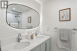 Modern bathroom featuring a dual vanity with undermount sinks, brushed nickel faucets, and a white countertop - 