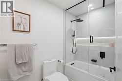 Contemporary bathroom featuring a combination tub and shower with a glass enclosure - 