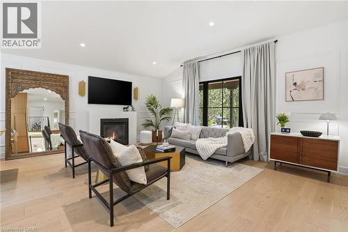 Spacious living area featuring light wood-finish flooring, a contemporary fireplace, and recessed lighting - 345 Rankin Drive, Burlington, ON - Indoor Photo Showing Living Room With Fireplace